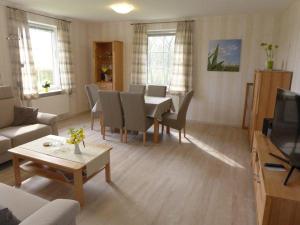 a living room with a table and chairs and a living room at Hus-Pellworm-1-Ferienwohnung-Meerestraum in Pellworm