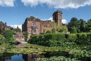 an old castle with a pond in front of it at New Hall Hotel & Spa, Birmingham in Birmingham