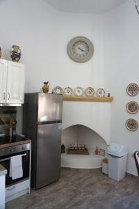 a kitchen with a refrigerator and a clock on the wall at Amalia's Traditional Home in Paradisi in Paradeísion