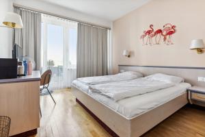 ein Hotelzimmer mit einem Bett und einem TV in der Unterkunft becozy du Lac Self-Check In Hotel Riviera Edition in Wädenswil