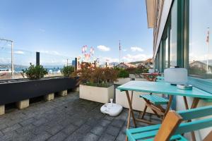 einen Tisch und Stühle auf einem Balkon mit Aussicht in der Unterkunft becozy du Lac Self-Check In Hotel Riviera Edition in Wädenswil