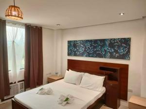ein Schlafzimmer mit einem Bett mit zwei Blumen drauf in der Unterkunft Hotel Rupert A Baler in Baler