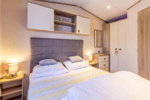 a bedroom with a large white bed with two pillows at Lovely Caravan At Azure Seas Nearby The Beautiful Beach Ref 32038az in Lowestoft
