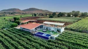 an aerial view of a house in a vineyard at SaffronStays Onellaa, Nashik - infinity pool villa surrounded by a vineyard in Nashik