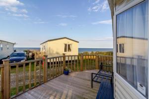a deck with a view of the ocean from a house at Lovely Caravan At Azure Seas Nearby The Beautiful Beach Ref 32038az in Lowestoft