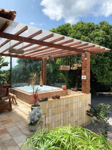 un patio con piscina y pérgola de madera en Casa de campo c vista para montanhas em Cha Grande en Chã Grande