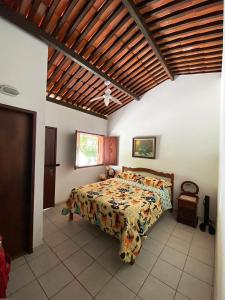 Casa de campo c vista para montanhas em Cha Grande في Chã Grande: غرفة نوم مع سرير مع لحاف متهالك