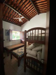 Casa de campo c vista para montanhas em Cha Grande في Chã Grande: غرفة نوم مع سرير بطابقين ومقعد في غرفة