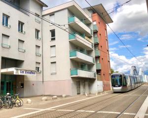 een trein in een straat naast een gebouw bij "Le Physalis" Élégant studio à 2 pas de Grenoble proche Tram in Fontaine
