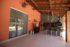 cocina con paredes de color naranja y ventana grande en Piscina e muito lazer em linda Chacara, Franca SP, en Franca