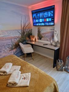 Una televisión o centro de entretenimiento en Ambre Mare Bursztynowe Apartamenty Pobierowo