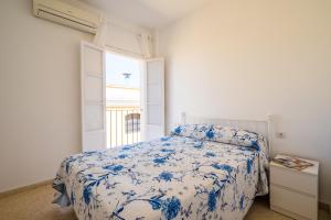 Un dormitorio con una cama azul y blanca y una ventana en Sevillano apto en Centro cerca de Santa Justa, en Sevilla