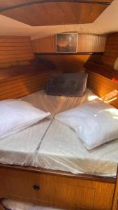 - un lit dans un bateau avec 2 oreillers dans l'établissement Voilier Eolia, à Prunete