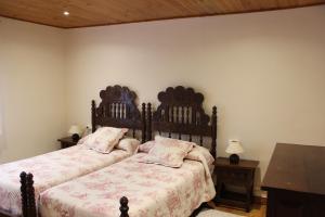 a bedroom with two beds and a wooden headboard at Cerezal 1 in Los Cándanos