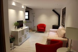 a living room with a couch and a red chair at Cerezal 1, casa en plena naturaleza 