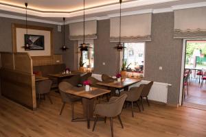 a restaurant with tables and chairs in a room at Komforthotel Kaiserhof in Kelbra