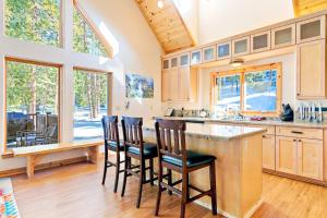 a kitchen with a bar with chairs and a table at Oso Lodge in Yosemite West