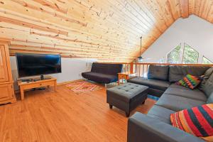 a living room with a couch and a flat screen tv at Oso Lodge in Yosemite West