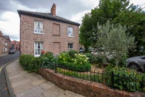 ein Backsteinhaus mit Garten davor in der Unterkunft George Street Boutique Apartments in York