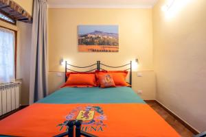 a bedroom with a large bed with orange pillows at IBibiena - SUITE DI DIEGO in Bibbiena