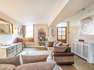 a living room with two couches and a kitchen at Anglers Cottage in Skipton