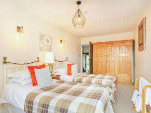 two beds in a guest room with at Anglers Cottage in Skipton