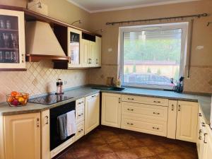 kuchnia z białymi szafkami i oknem w obiekcie Hostel Dalia w Zielonej Górze +6 zdjęć