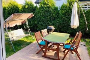 um pátio com uma mesa, cadeiras e um guarda-sol em Hostel Dalia em Zielona Góra