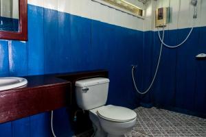 La salle de bains bleue est pourvue de toilettes et d'un lavabo. dans l'établissement Nongsak Riverside Guesthouse & Nongsak Guesthouse, à Ban Khon