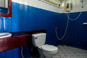 a blue bathroom with a toilet and a sink at Nongsak Riverside Guesthouse & Nongsak Guesthouse in Ban Khon