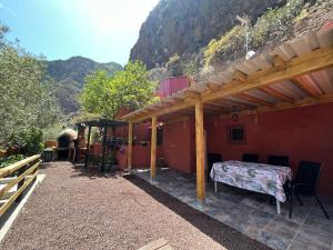 um pátio de uma casa com uma mesa e uma montanha em Casa Rural Guayadeque Ca'Juani em Ingenio