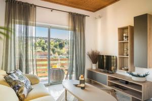a living room with a tv and a large window at Malibu Superior Apartment in Argostoli