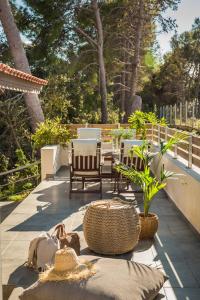 a patio with chairs and tables and trees at Malibu Superior Apartment in Argostoli