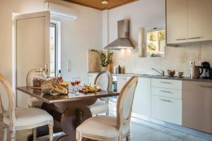 a kitchen with a table and chairs with wine glasses at Malibu Superior Apartment in Argostoli