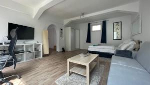 ein Wohnzimmer mit einem Sofa und einem Tisch in der Unterkunft Oase im Hinterhofhaus,Terrasse, Fahrräder, Parkplatz, Ruhe, Netflix in Duisburg