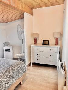 - une chambre avec un lit et une commode avec un miroir dans l'établissement Maison 2 Chambres - TV - CLIM - BABY FOOT, à Ruelle-sur-Touvre