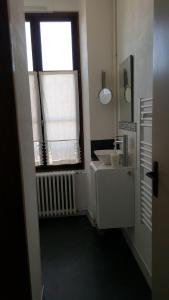 a bathroom with a sink and a window at La Palette Fleurie in Laignes