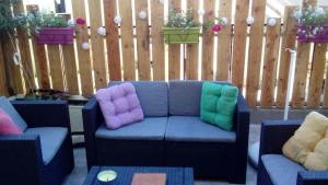 un sofá azul con almohadas coloridas en el patio en La Palette Fleurie, en Laignes