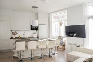 uma cozinha com armários brancos e uma mesa e cadeiras em Casa MIMOSA Vigo em Vigo