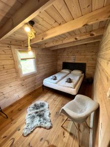 a bedroom in a log cabin with a bed and a chair at Domki Letniskowe Pola in Ryn