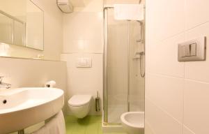 a bathroom with a sink and a toilet and a shower at Hotel Trieste Mare in Lignano Sabbiadoro