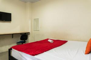 een kamer met een bed met een rode handdoek erop bij KoolKost near State Museum of North Sumatera Medan in Medan