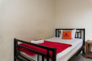 een slaapkamer met een bed met een rode deken bij KoolKost near State Museum of North Sumatera Medan in Medan