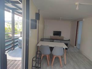 a table and chairs in a room with a balcony at Ti Kaz Fond de Puits in Saint-Philippe