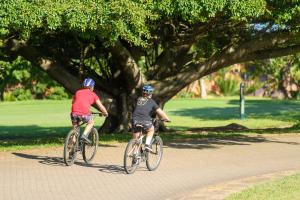 duas pessoas a andar de bicicleta numa estrada num parque em San Lameer Villa 2814 - 3 Bedroom Classic - 6 pax - San Lameer Rental Agency em Southbroom