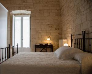 um quarto com uma cama e uma parede de tijolos em Da Concavo e Convesso em Locorotondo