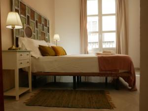 a bedroom with a large bed with a window at Sierpes 50 in Seville