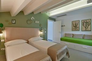 1 dormitorio con 2 camas y pared verde en Villa Nausica pool view on the sea wifi free perfect for big group, en Ragusa