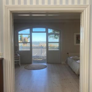eine offene Tür zu einem Schlafzimmer mit einem Bett und einem Balkon in der Unterkunft Rødvig Kro og Badehotel in Rødvig