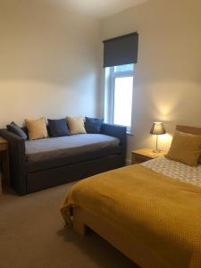 uma sala de estar com um sofá e uma cama em Luxury house with Sea views em Bangor